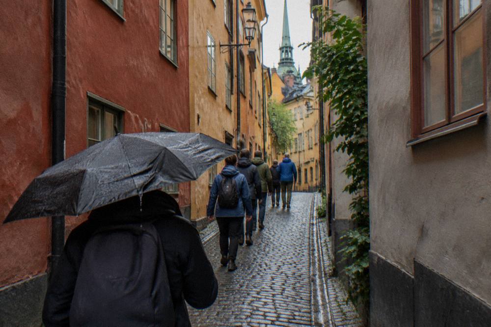 Visitors walking with a guide along a narrow cobblestone alley in Stockholm's Old Town