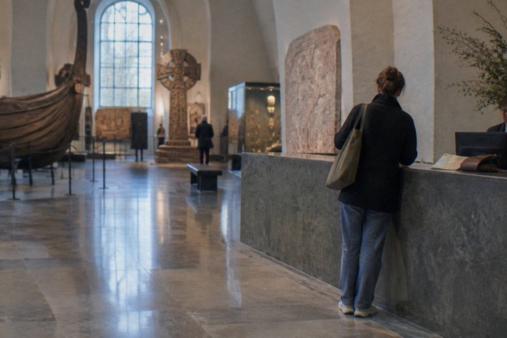A museum ticket desk in Stockholm with a visitor reading the admission sign