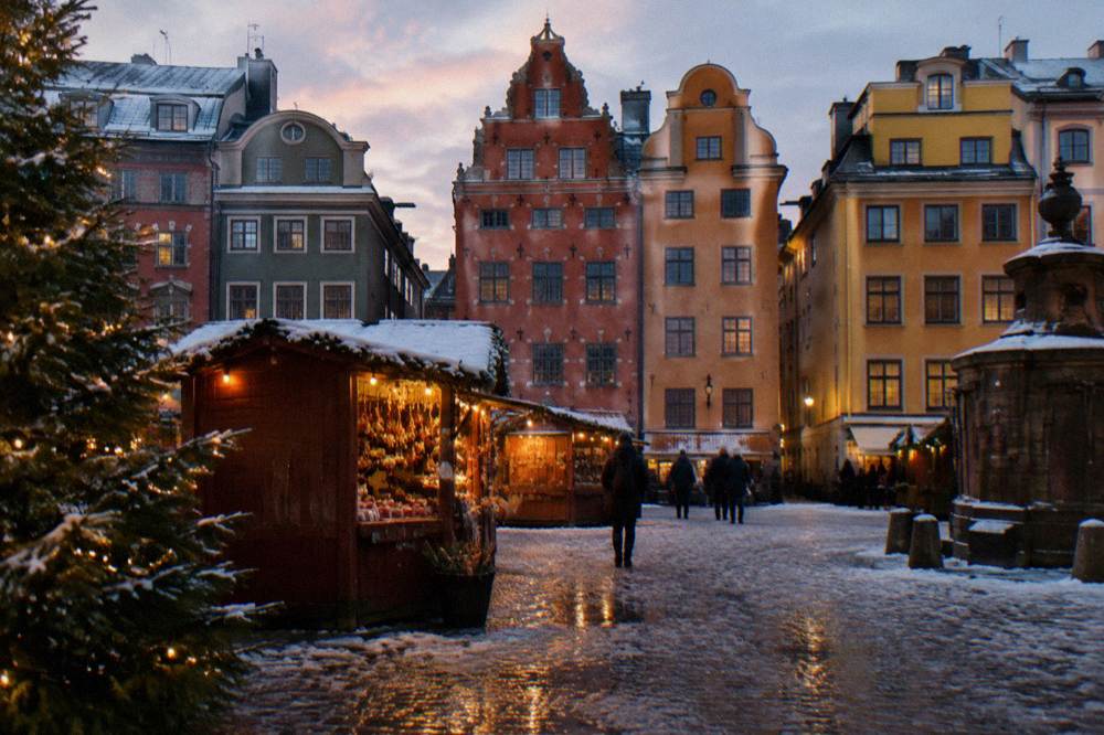 Snow-dusted Stortorget square in Stockholm's Old Town with pastel building facades at dusk