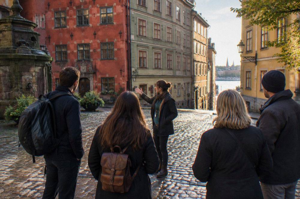 A guide speaking to a small group of visitors in a Stockholm Old Town square