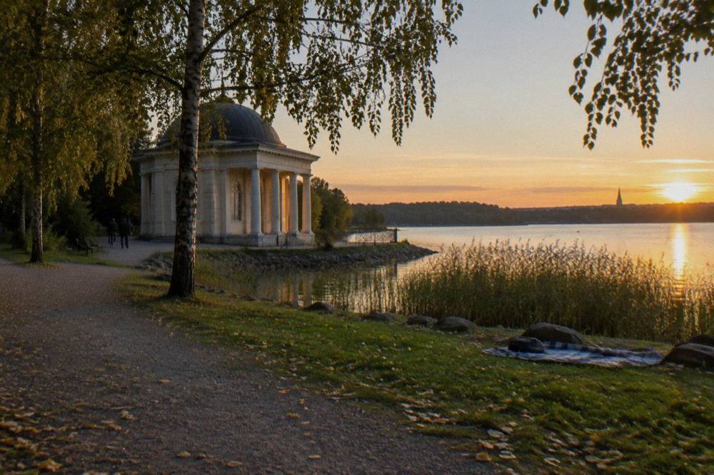 A neoclassical pavilion beside a calm bay at Hagaparken, seen from the shoreline path