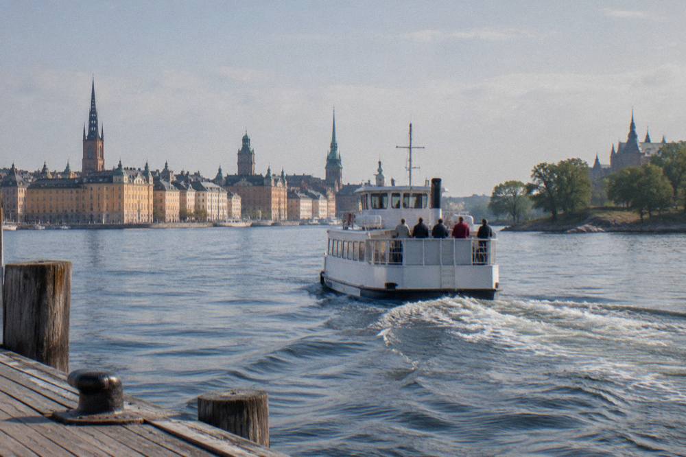 An SL ferry crossing Stockholm harbor toward Djurgården with the city skyline behind it