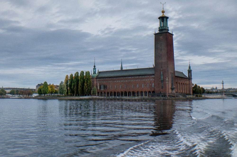 Stockholm City Hall seen from across the water, with its brick tower and waterside arcade
