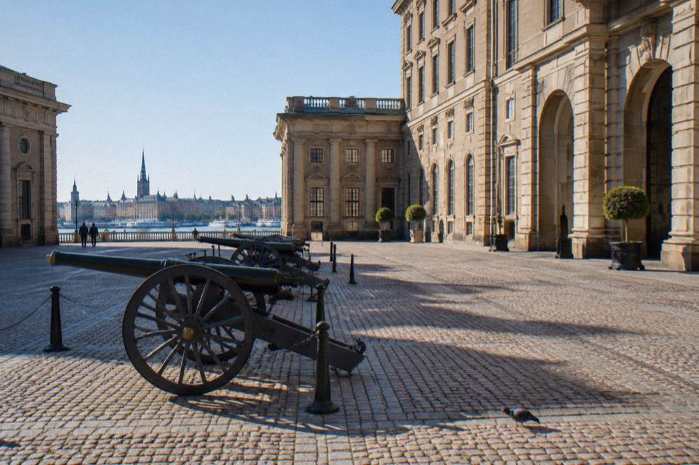 The Royal Palace Outer Courtyard in Stockholm on a bright day, with the palace facade behind a cobbled open square