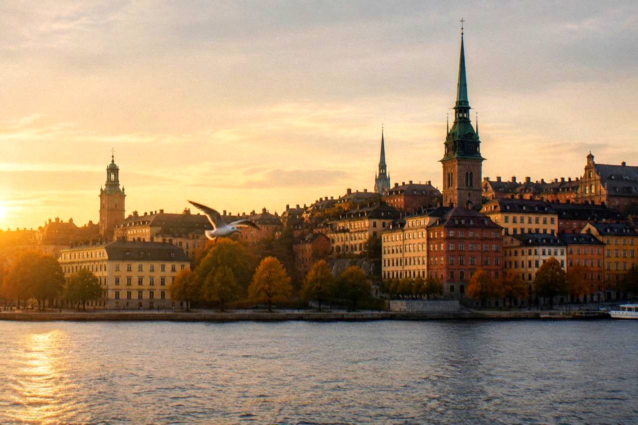 Stockholm's Gamla Stan old town rooftops and church spires seen across the water at golden hour