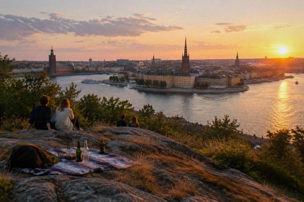 A panoramic view of Stockholm's old town and water from a high viewpoint path at golden hour