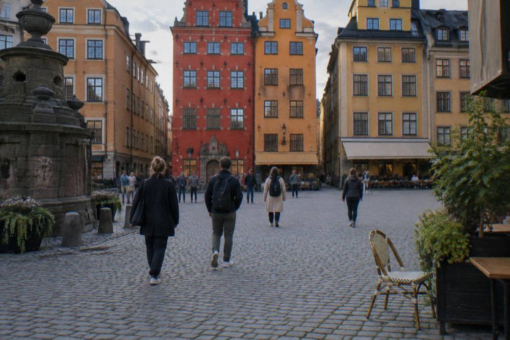A street in Stockholm's Old Town with narrow coloured buildings and a small crowd of walkers